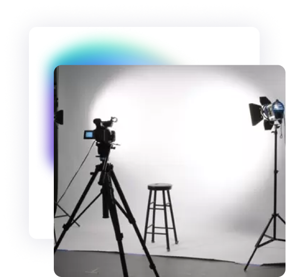 A studio with floor lighting and a camera mounted on a tripod facing the studio's white background kit.