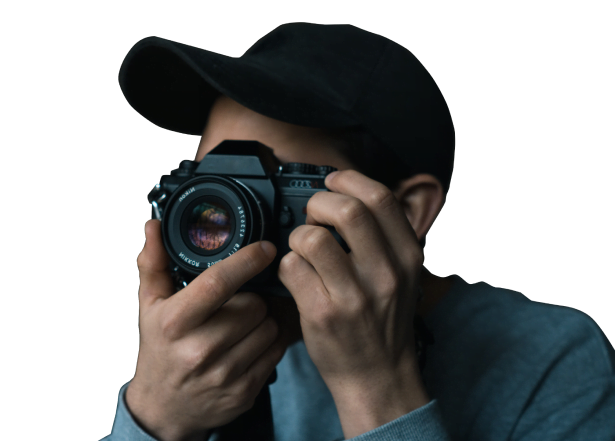 A young photographer from Satu Studio creative agency in a black hat is taking a picture with a Nikon mirrorless camera.